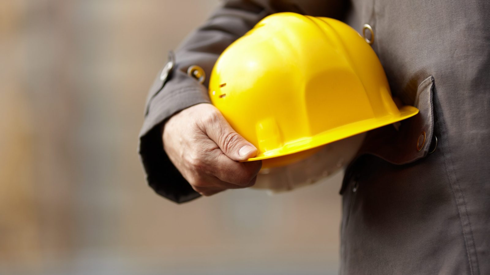 Worker holding onto a hard hat.